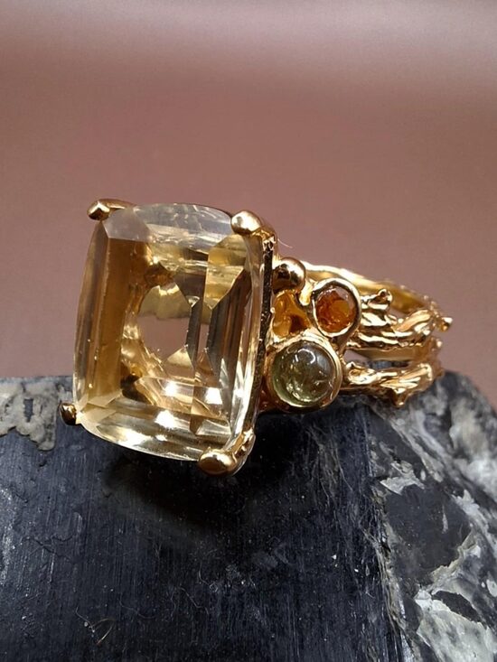 Zaļais ametists, granāts, peridots. Sudrabs ar zelta pārklājumu. Virsma 1,4 cm. Izm. 18. 