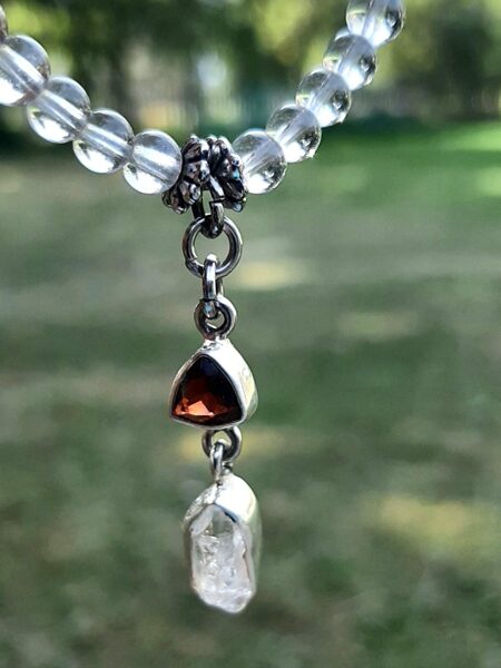 Mountain crystal. Herkimer diamond, garnet pendant. 20 cm.